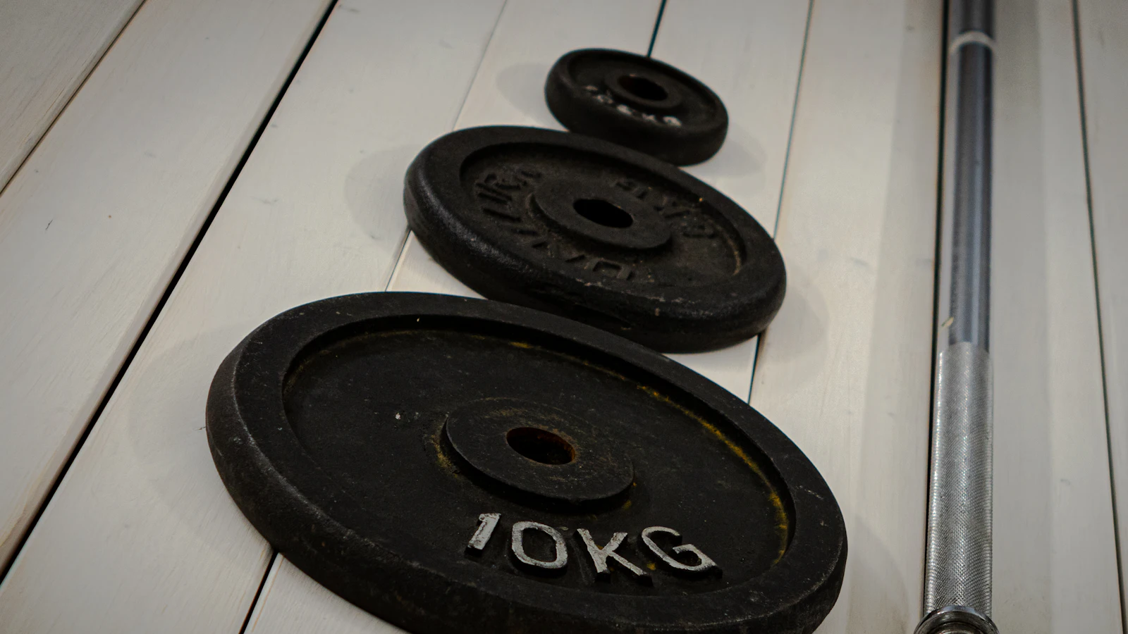 Close-up of weight plates loaded on a barbell