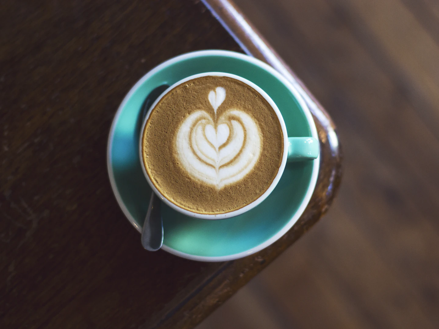 Coffee with milk in a turquoise cup and saucer